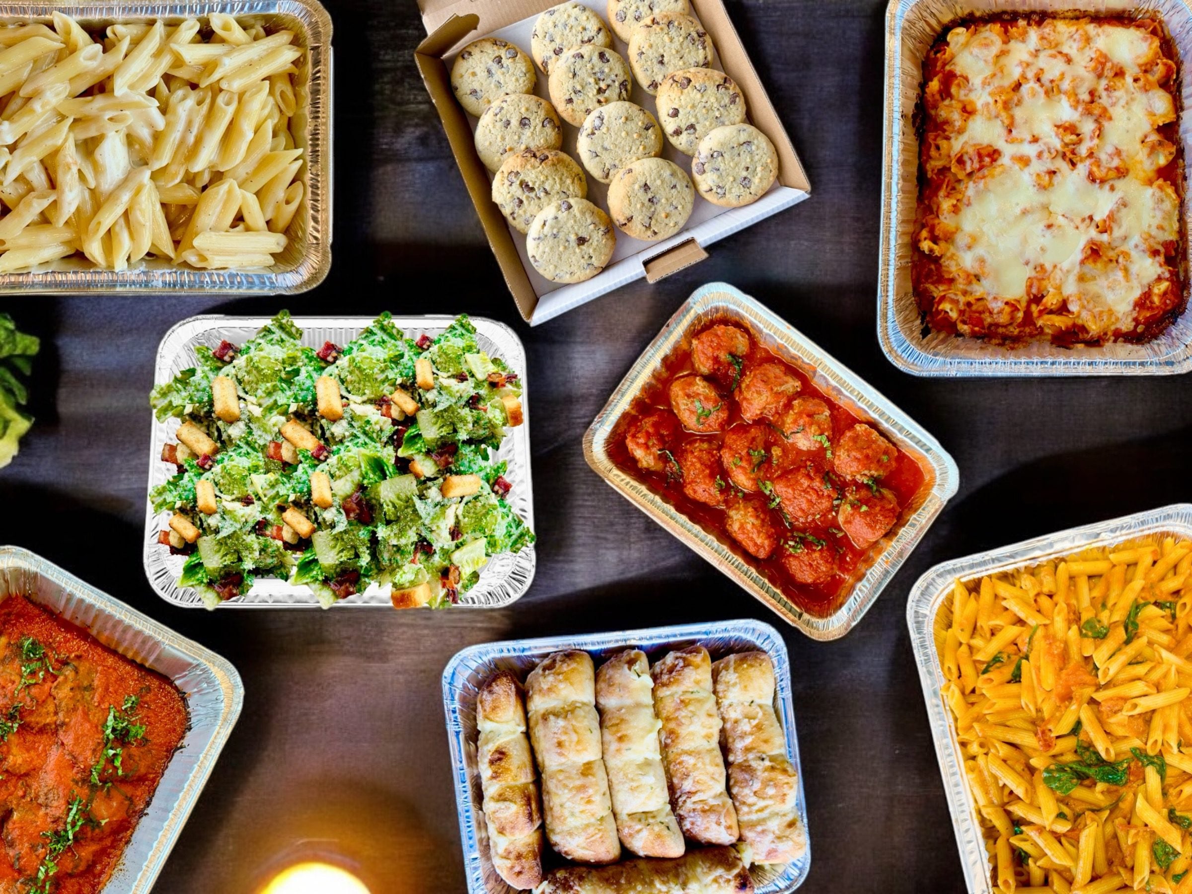 Via Cibo catering spread with pasta, salad, meatballs, bread and cookies